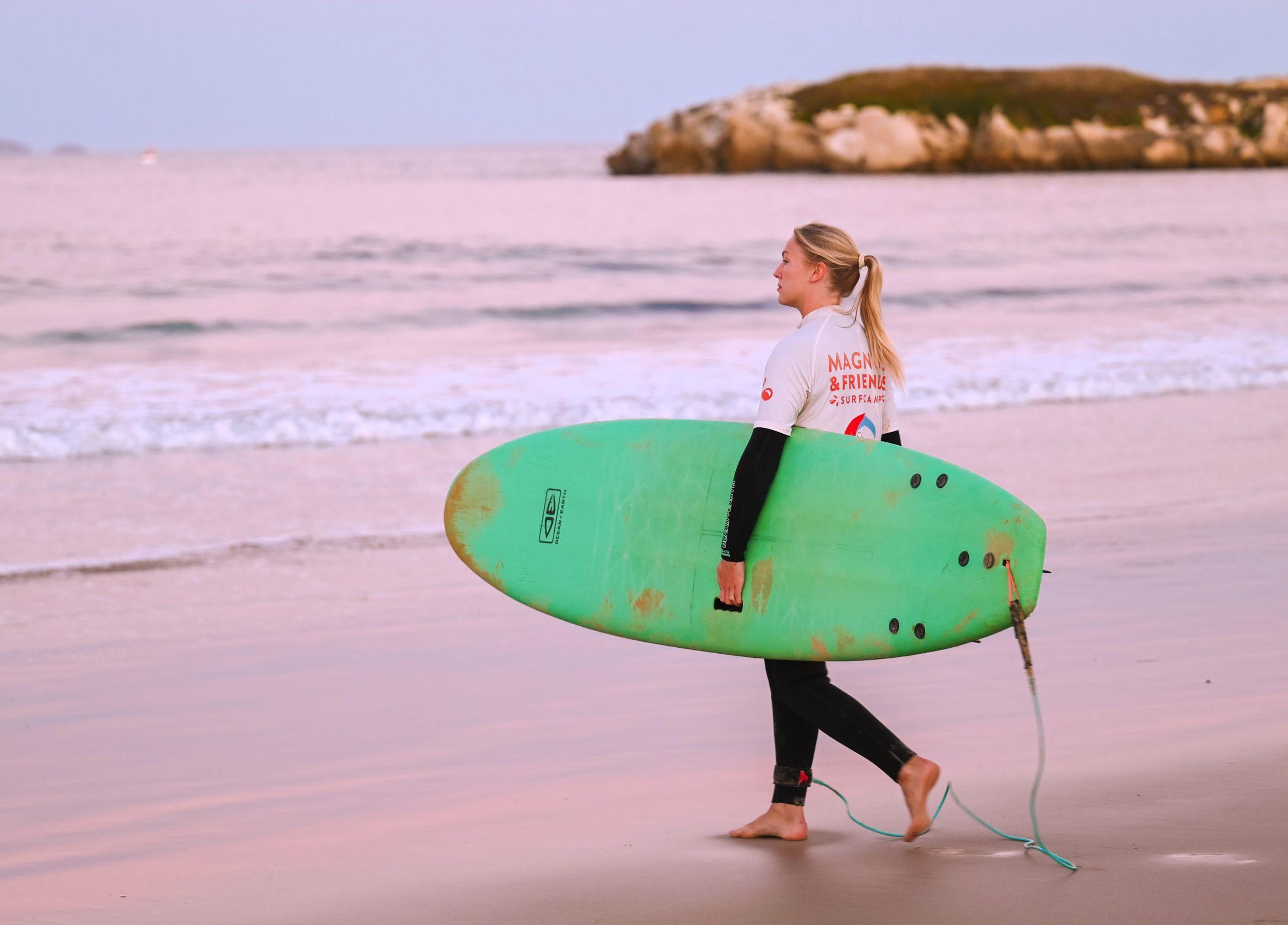 Surfare på väg ut i havet på en sunrise surf