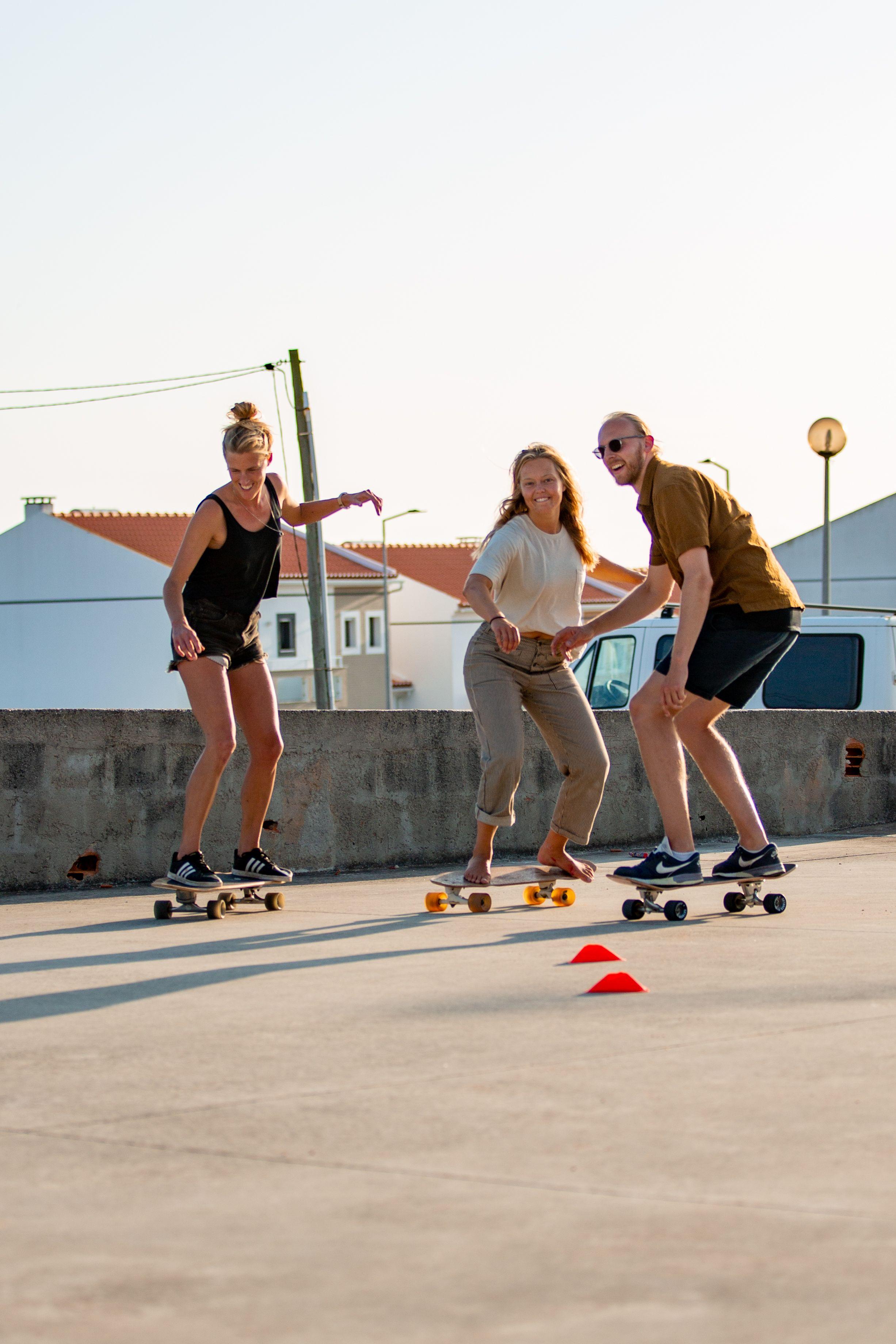 Grupp med tre personer under en surfskate-lektion.